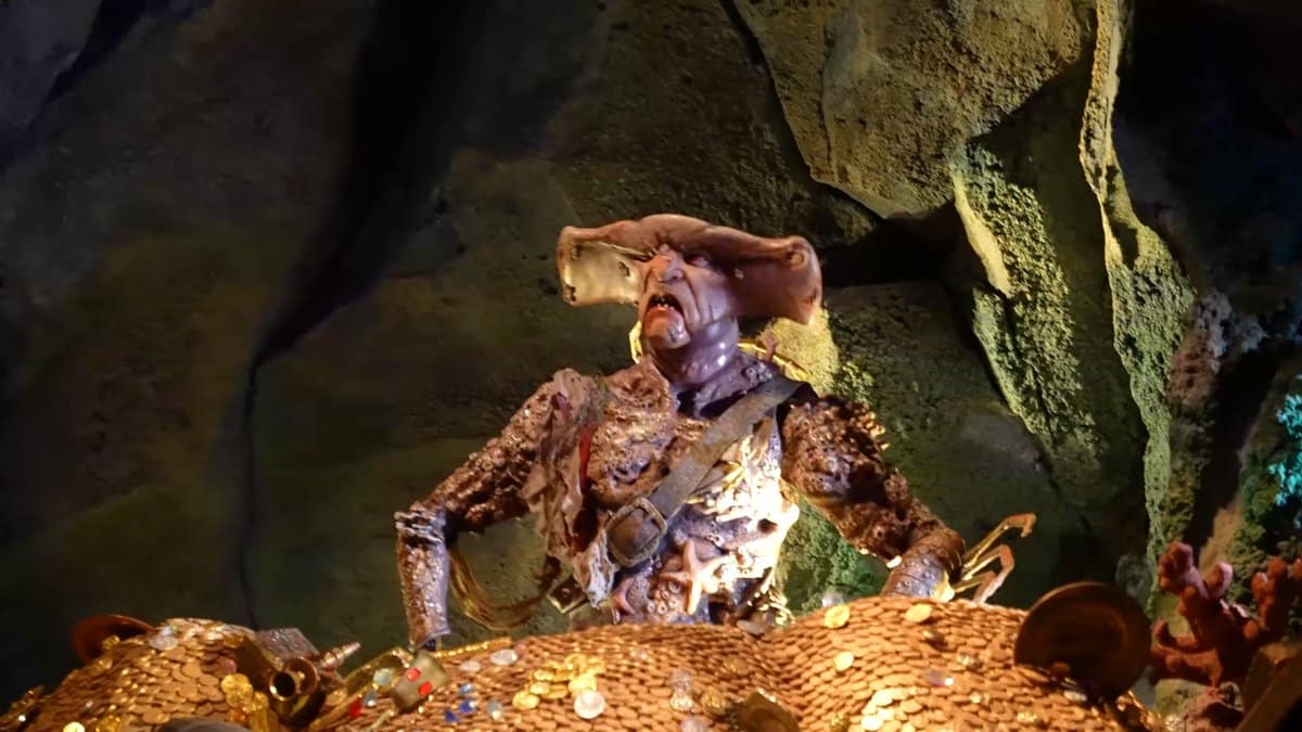 A pirate figure seated among piles of treasure.