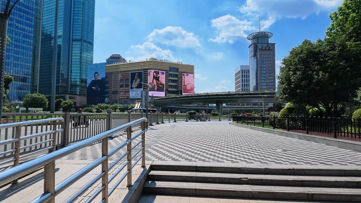 A zigzag-paved plaza beside the elevated walkway, a