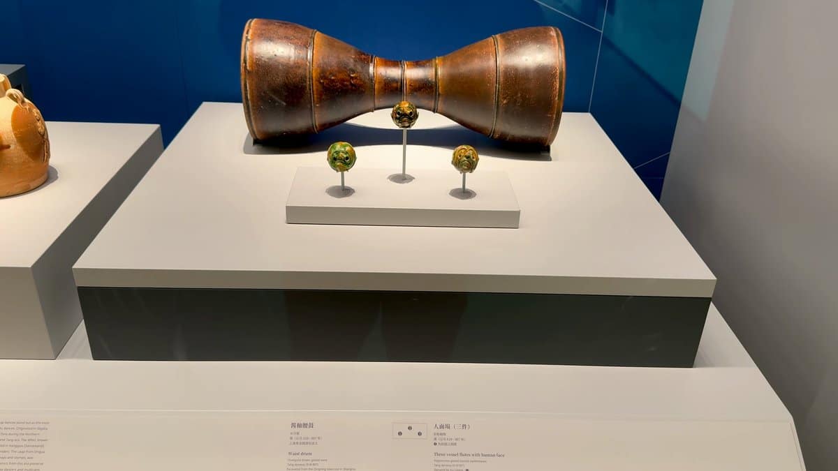 An hourglass-shaped vessel with small ornaments on stands