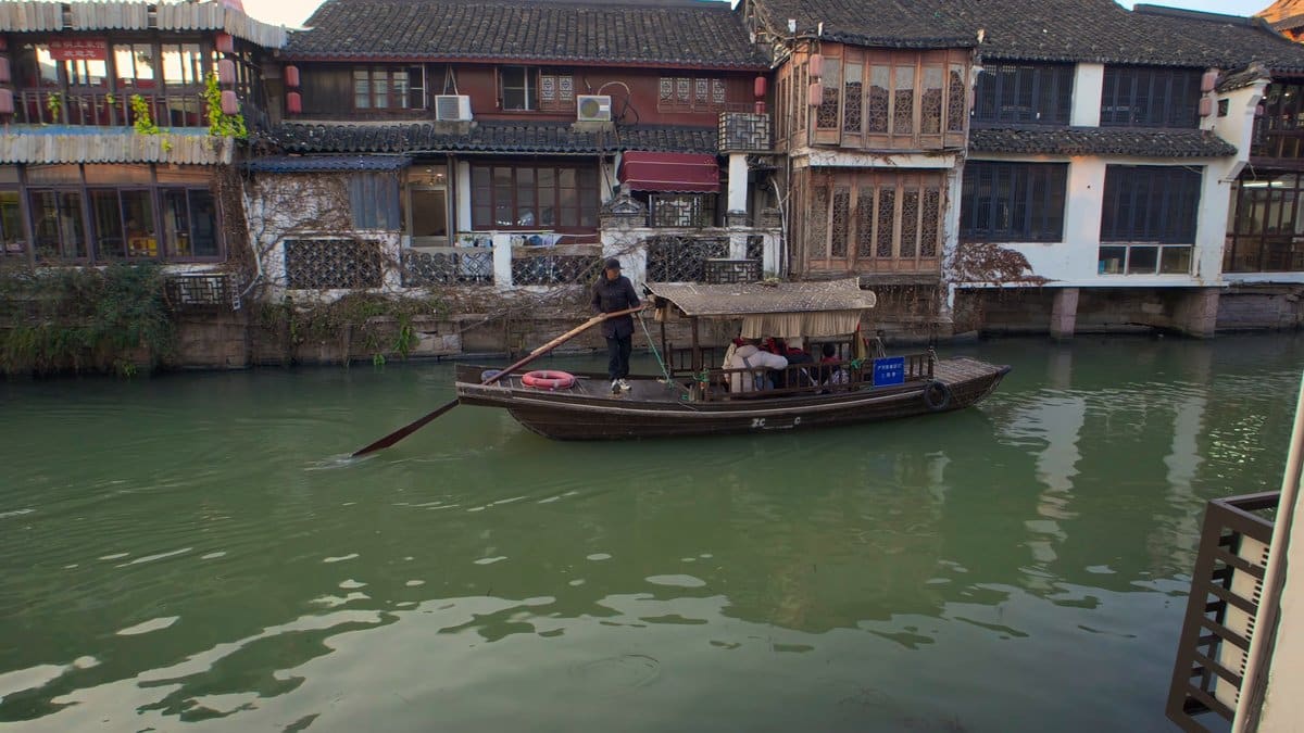 Boatman sculling a canopied sampan