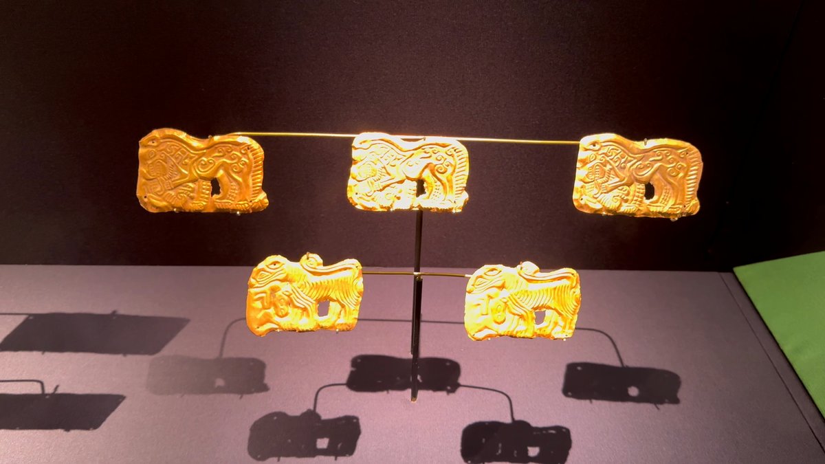 Gold plaques shaped as animals mounted on pins.
