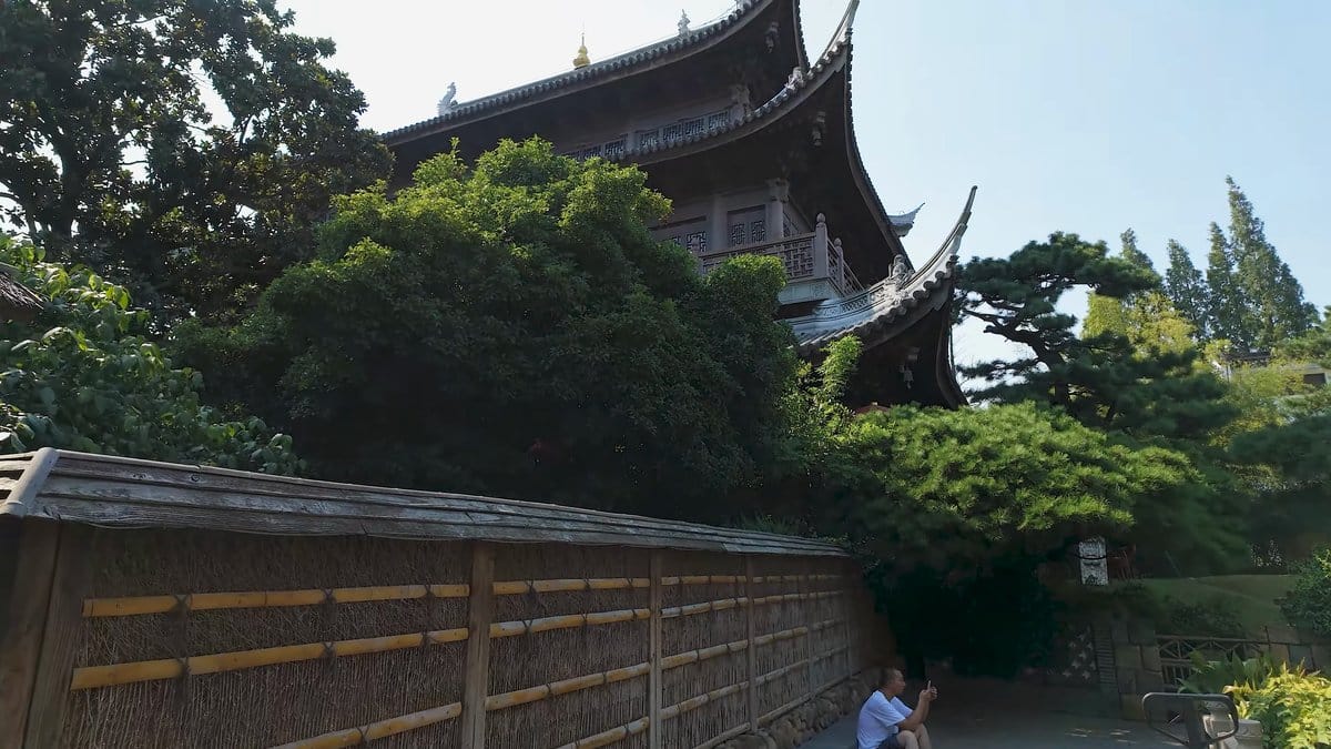 Hall roof beyond a bamboo fence