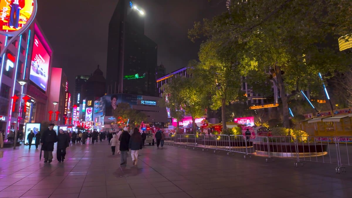 Pedestrians strolling past a lit garden