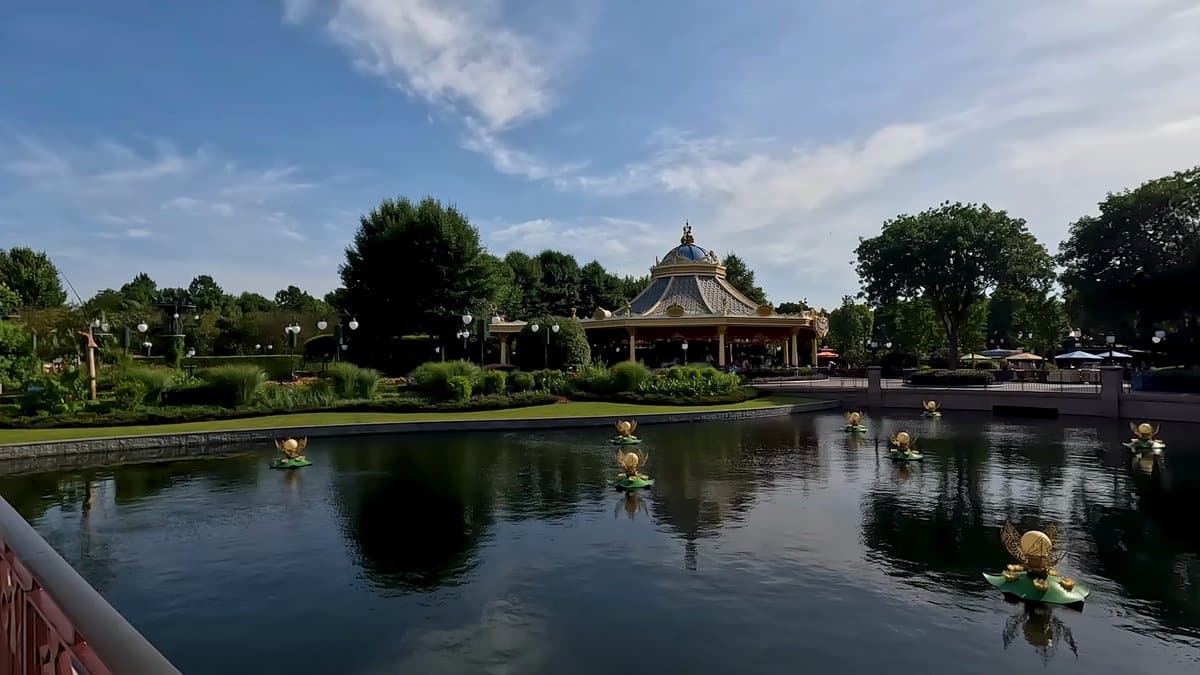 The lake reflecting a round pavilion and trees.