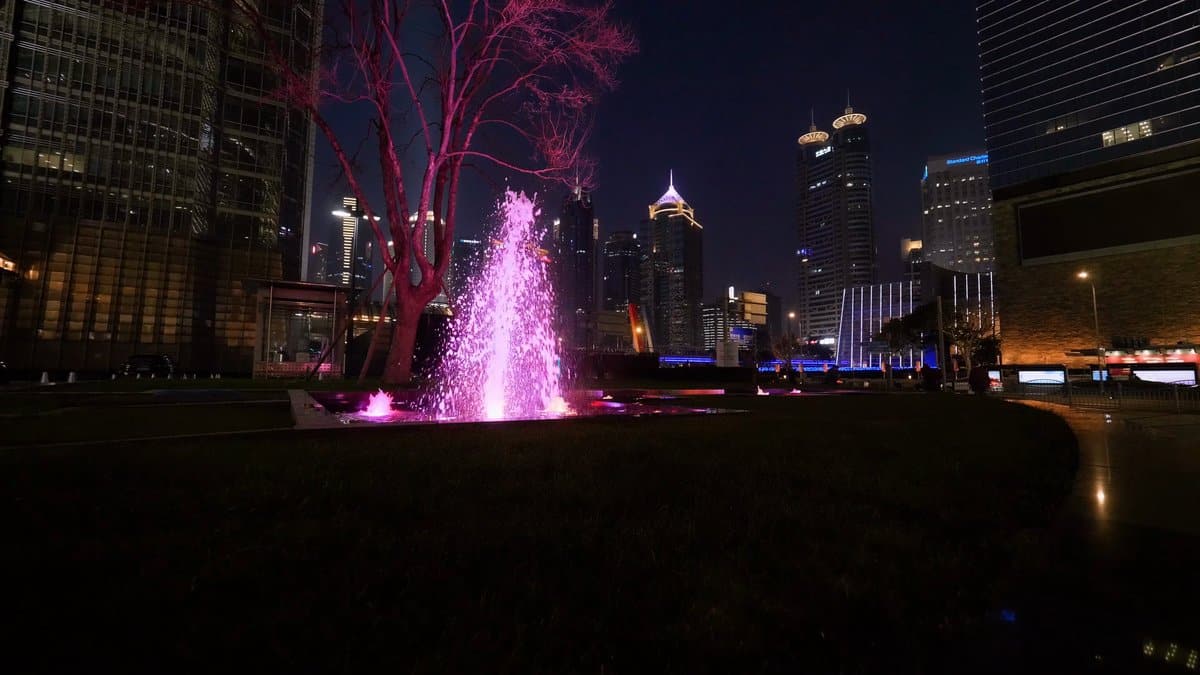 The same fountain now lit pink under a