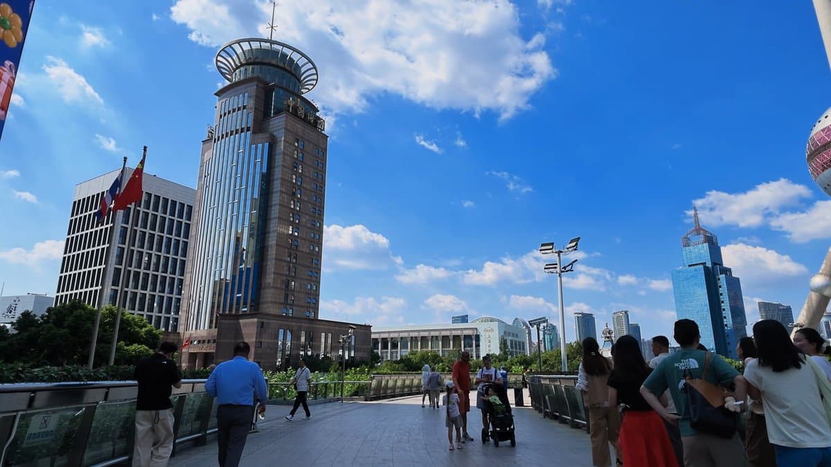 The skywalk busy with people, the disc-crowned tower