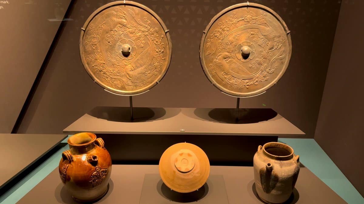 Two bronze mirrors above a row of small