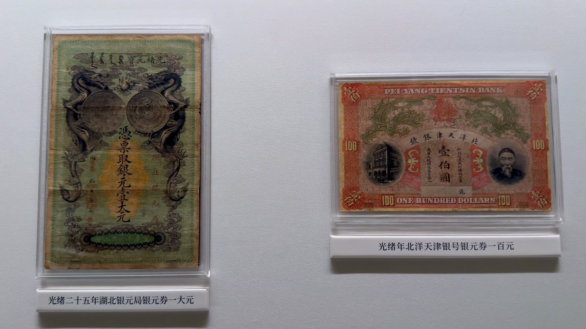 Two old banknotes in cases, one green and