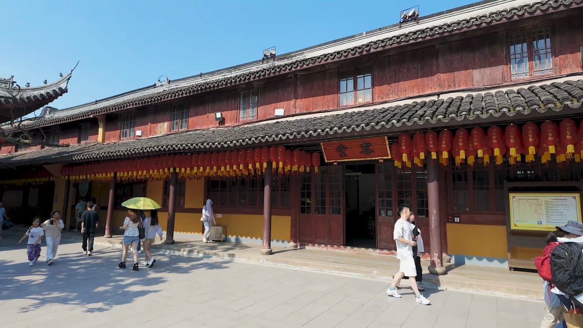 Visitors with parasols among timber halls