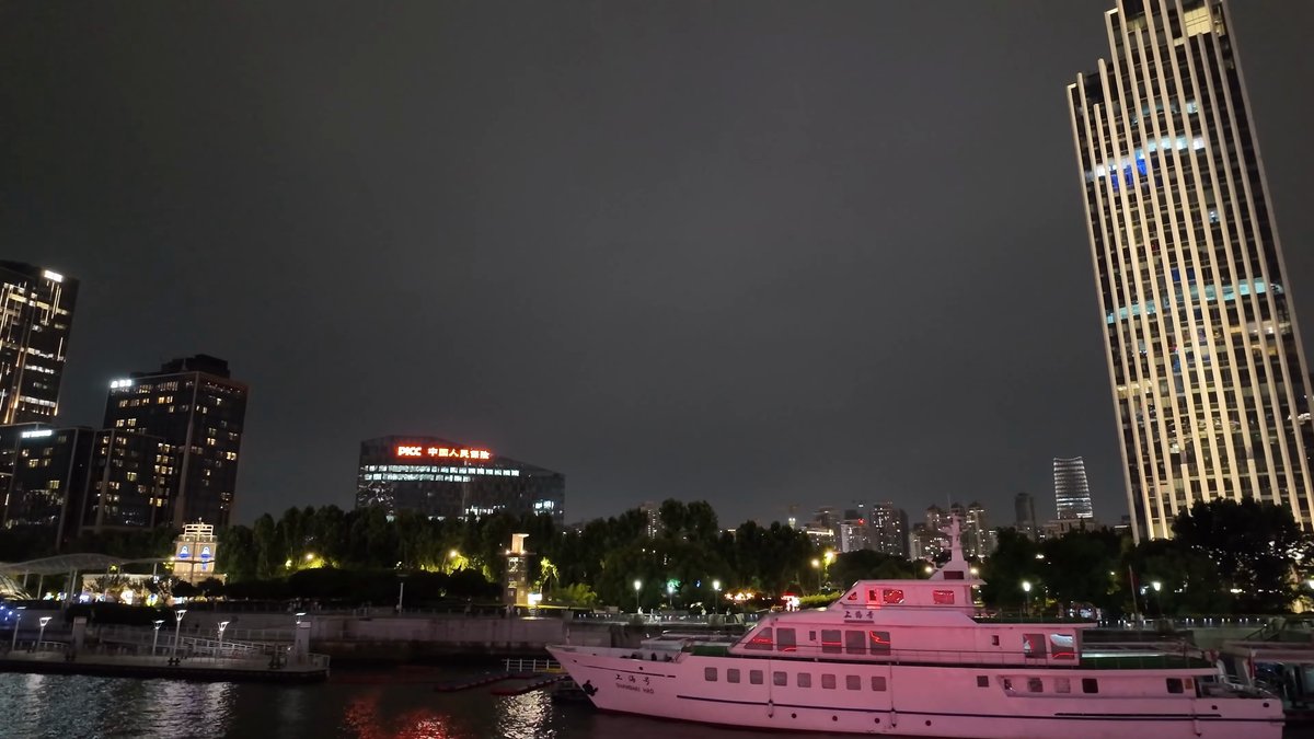 White ferry passing a riverside tower